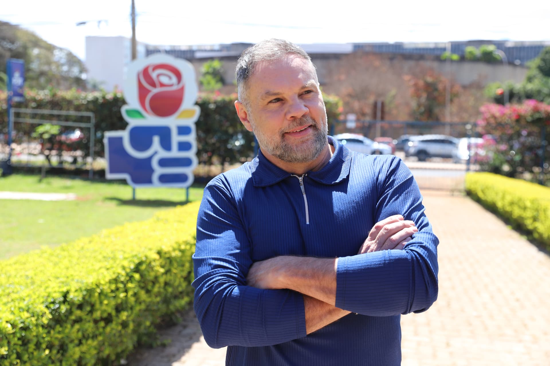 Paulo Tavares com braços cruzados em frente a placa do PDT